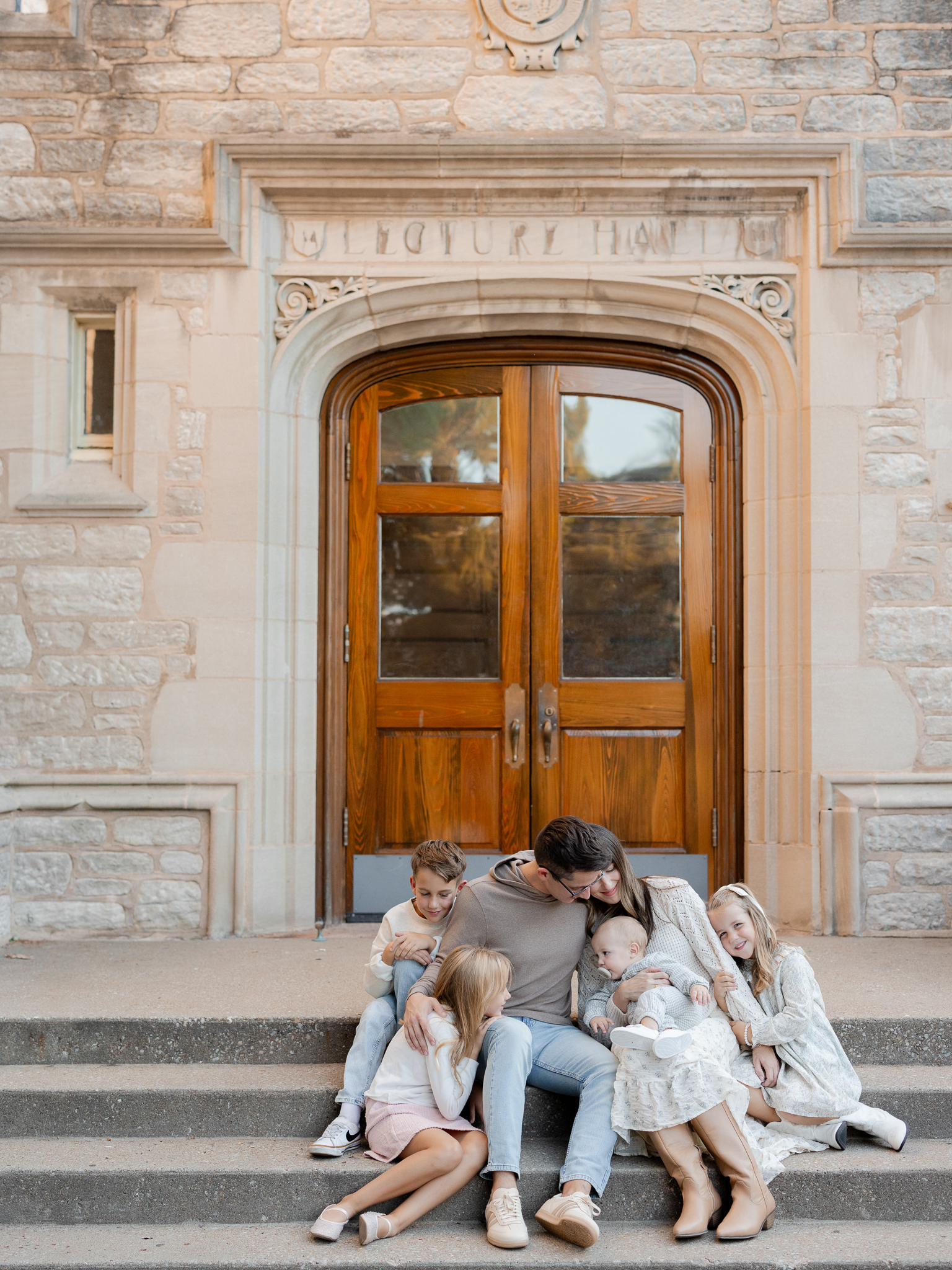 Parents and children sharing a sweet, relaxed moment in front of a historic wooden doorway in Columbia, captured by Love Tree Studios.