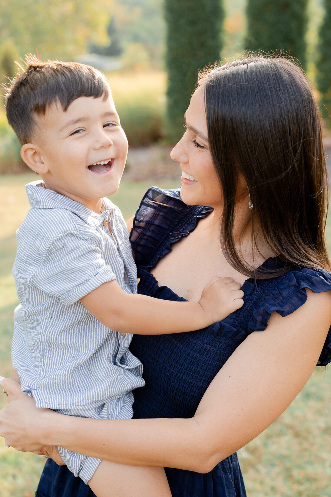 Candid moment of mom smiling at her son as he laughs, captured during a Stephens Lake Park session.