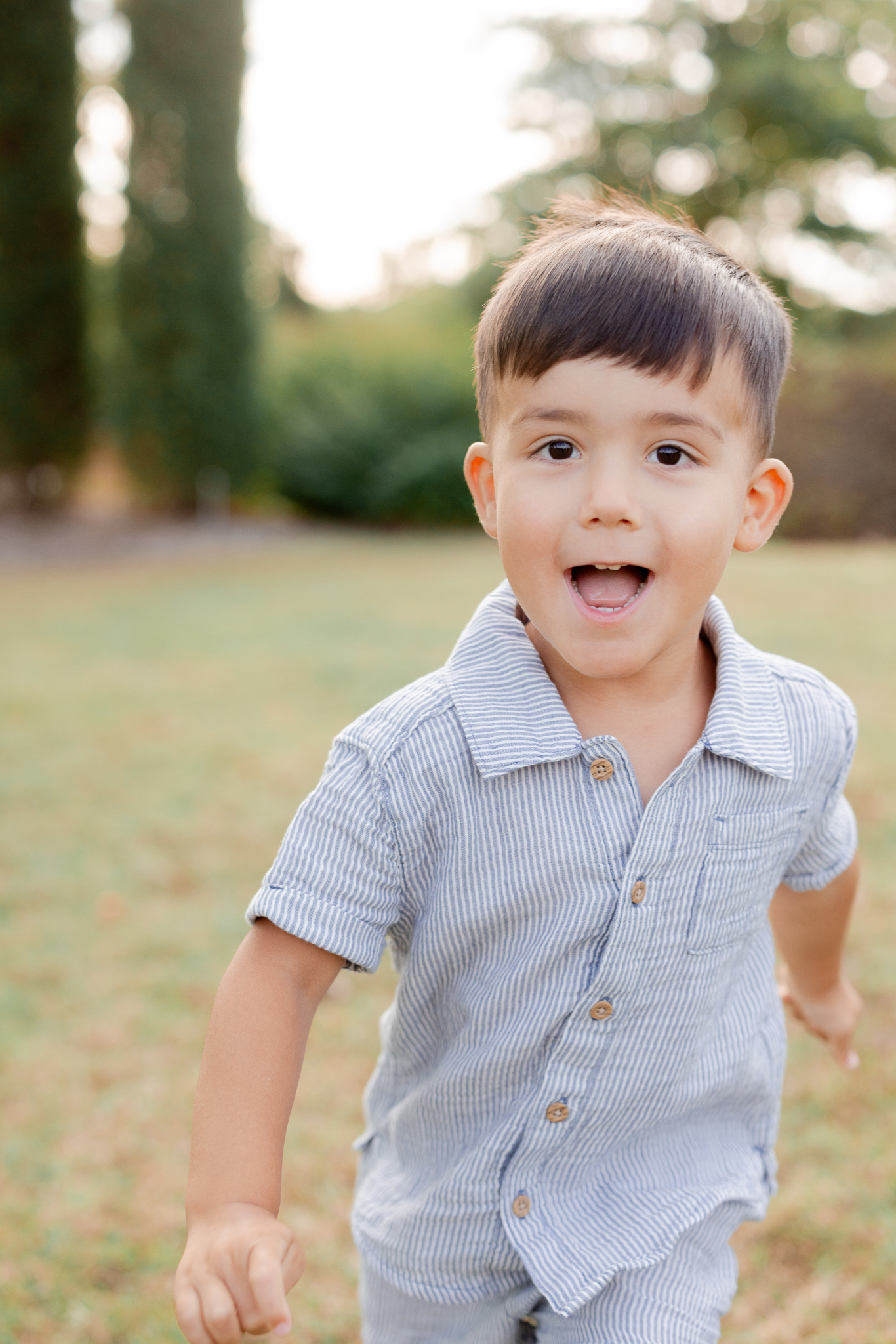 Young boy running toward the camera during a family photo session at Stephens Lake Park in Columbia Missouri.