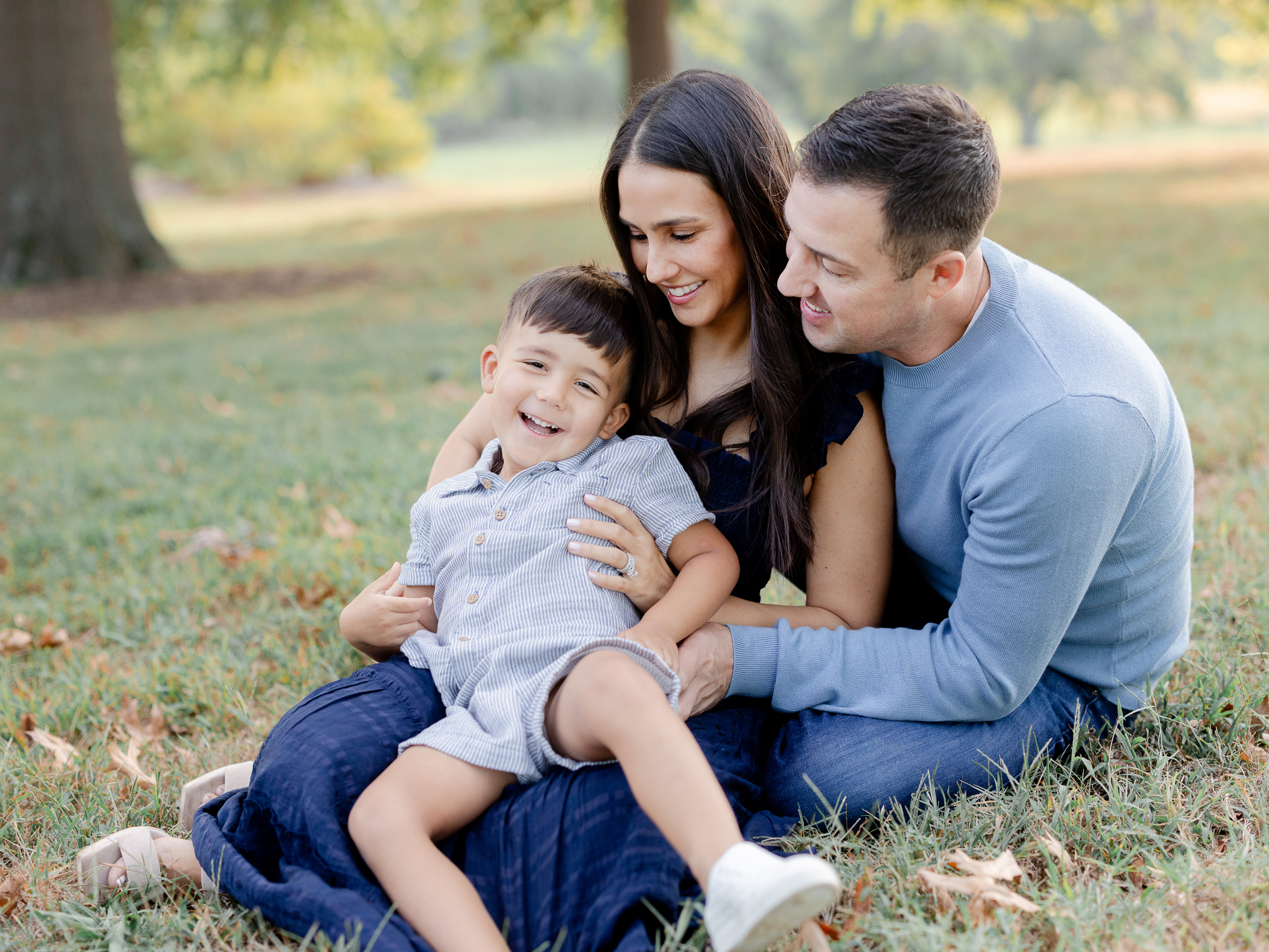 Little boy smiling while being held during a golden-hour session at Stephens Lake Park.