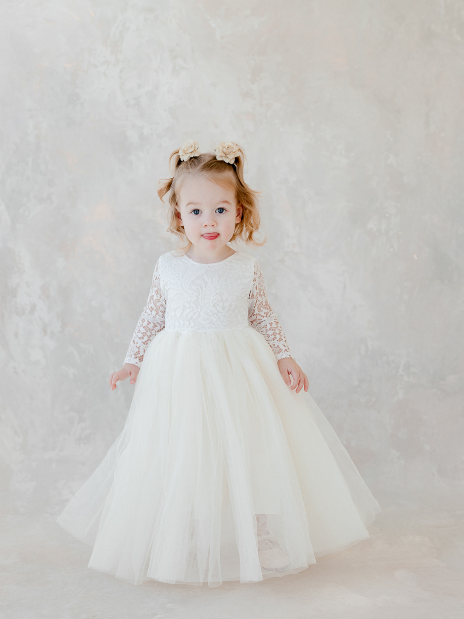 Toddler girl standing in white tulle dress during milestone session with Columbia Missouri family photographer.