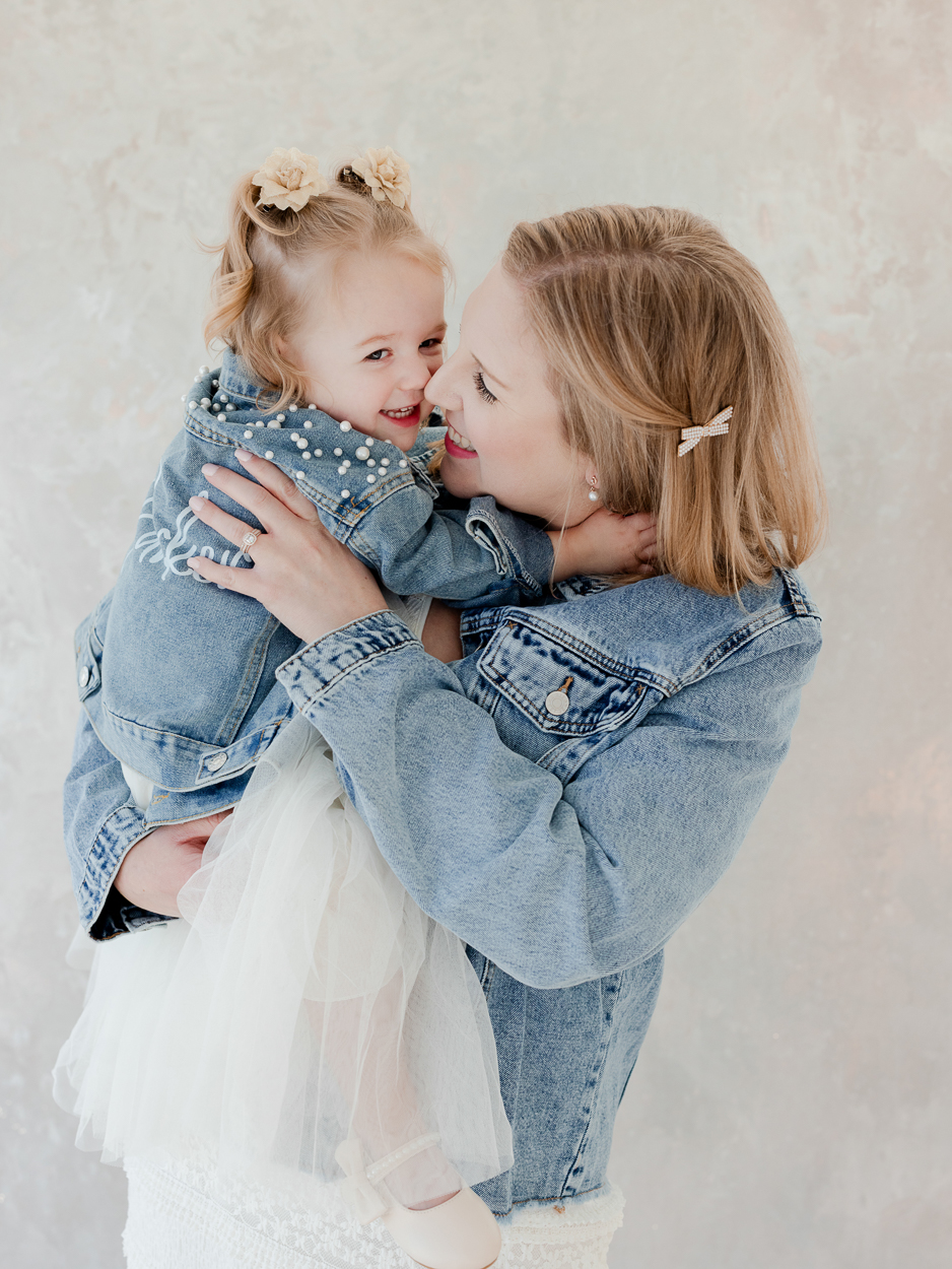 Mother and two year old daughter wearing matching denim jackets during Columbia Missouri family photography session.