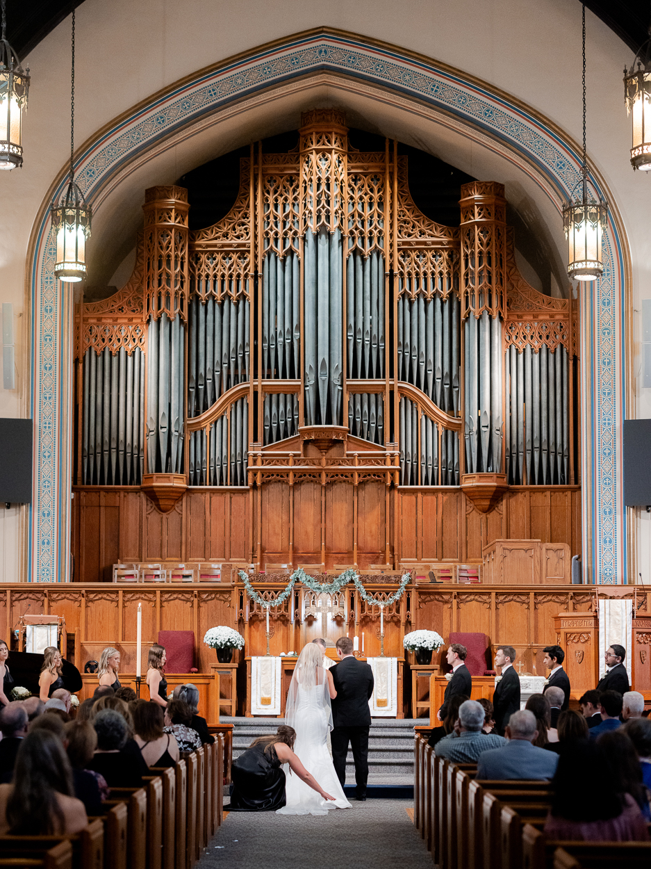 Wide ceremony view featuring the grand pipe organ and arched architecture during a Columbia Missouri church wedding.