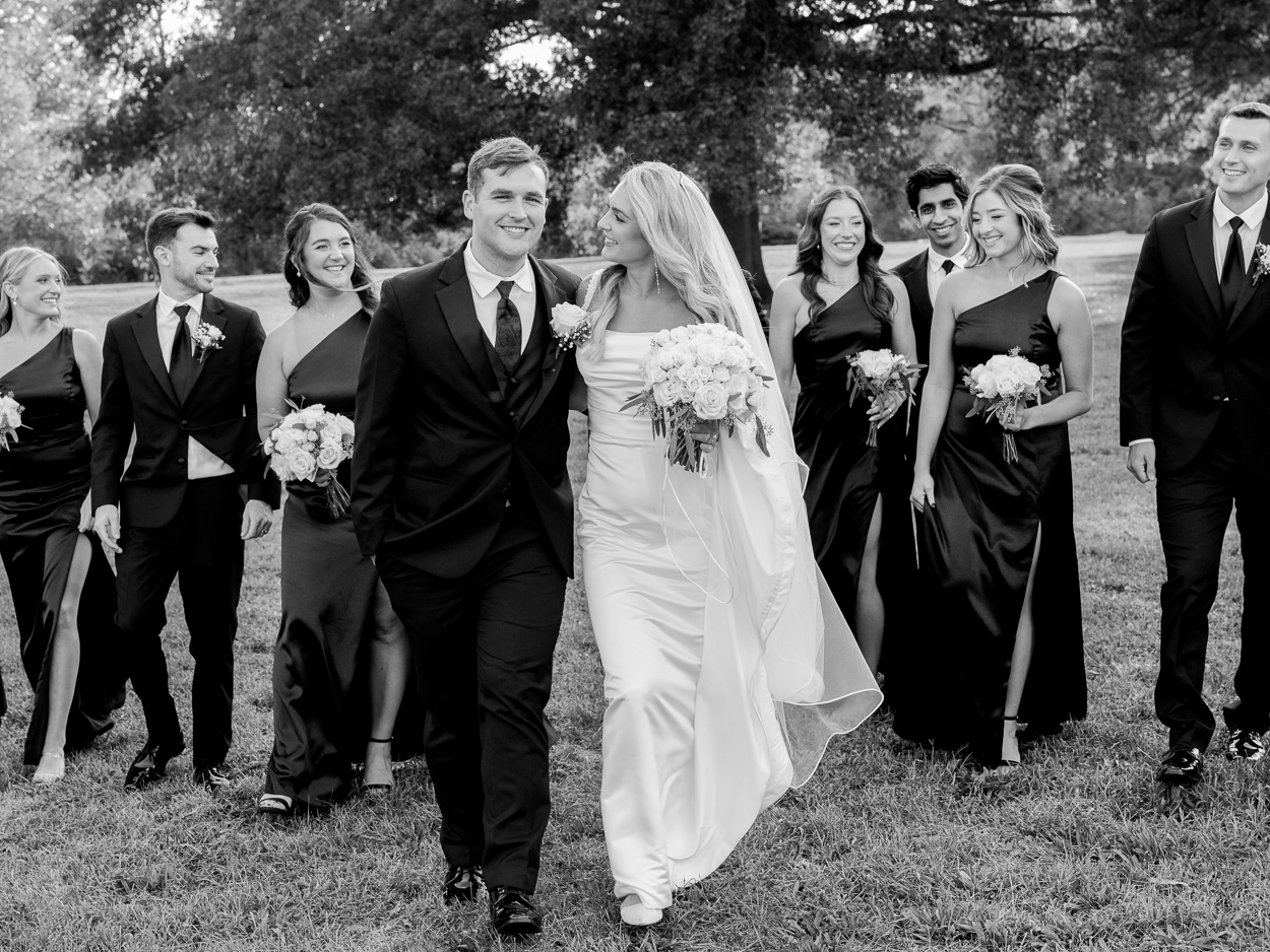 Wedding party walking together through Stephens Lake Park after a Columbia Missouri church wedding.