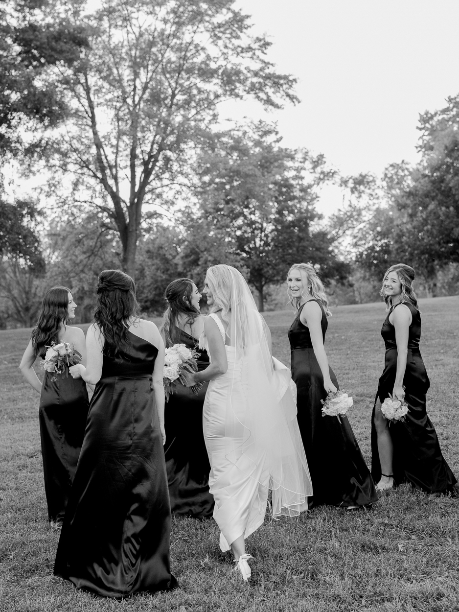 Bride laughing with her bridesmaids during golden hour portraits after their Columbia Missouri church wedding.