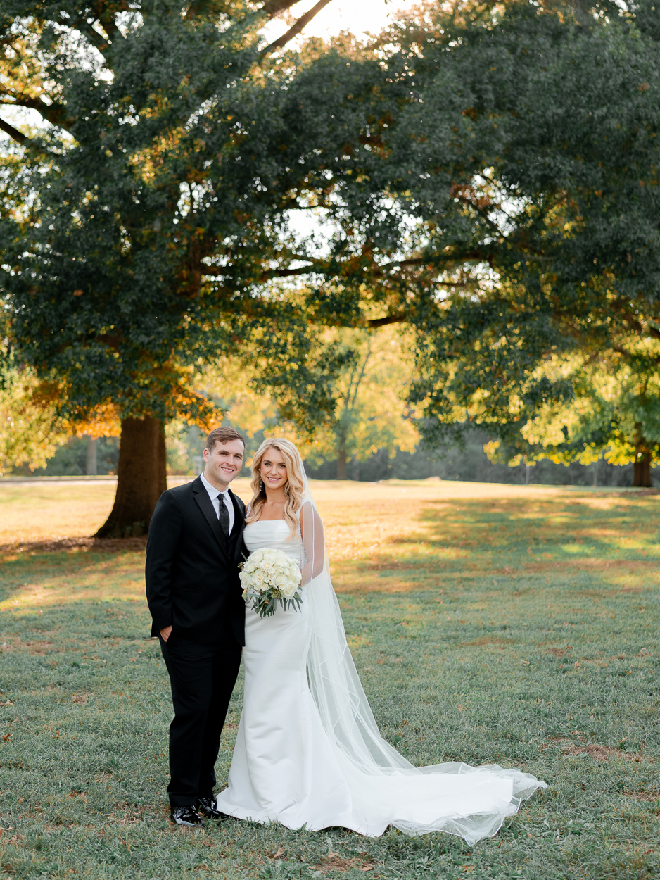 Newlyweds posing together at Stephens Lake Park after their Columbia Missouri church wedding ceremony.