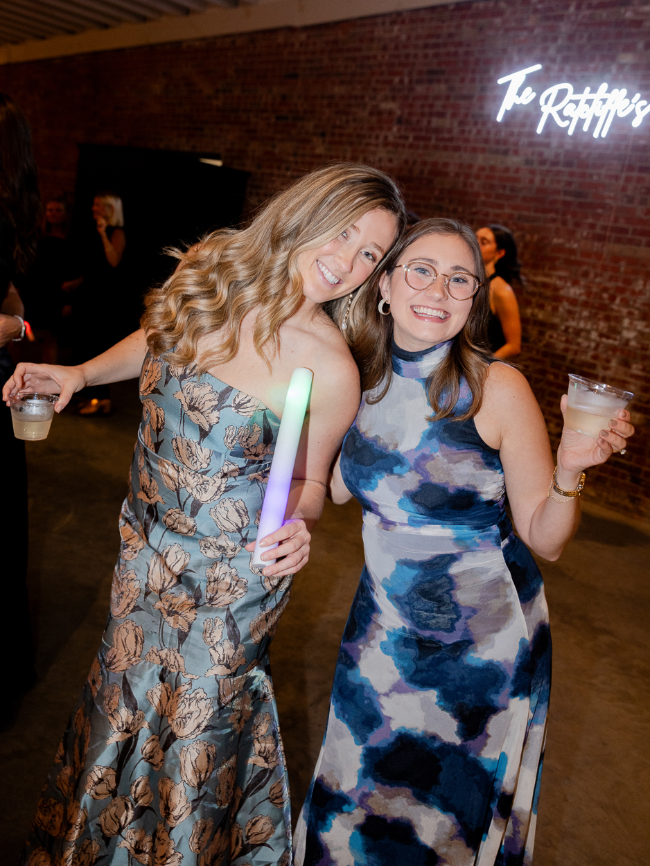 Wedding guests smiling and dancing with glow sticks at The Atrium on Tenth in Columbia, Missouri.