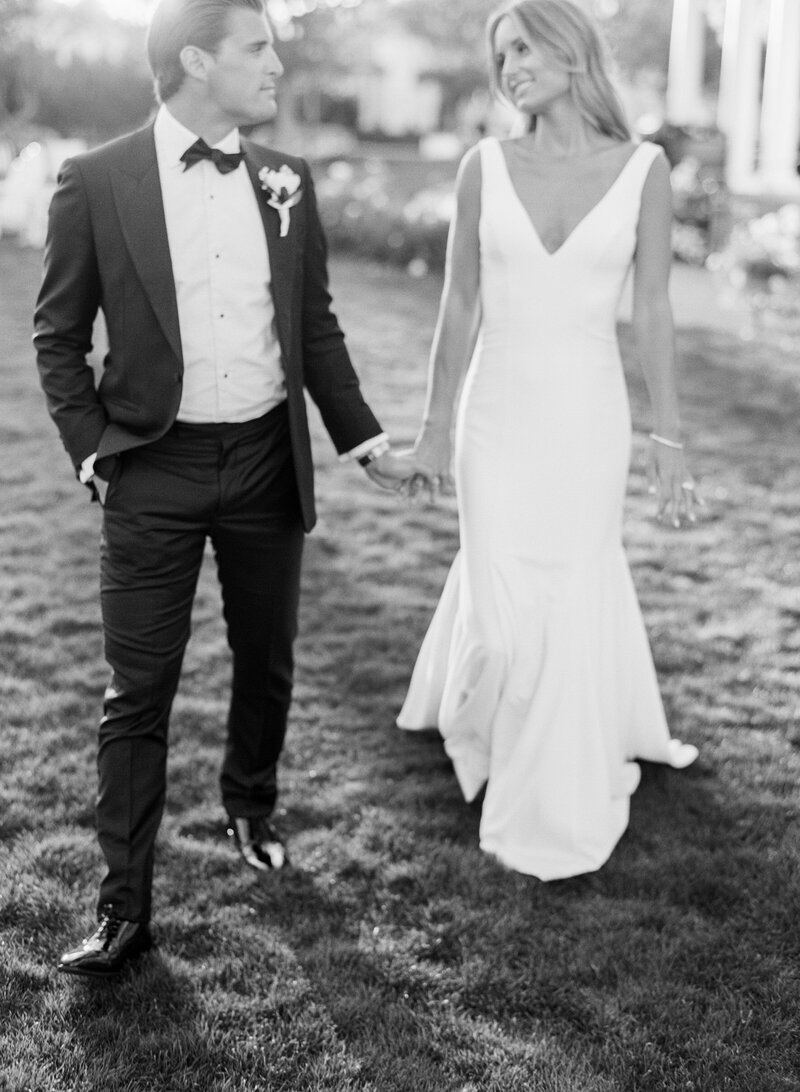 Black and white film portrait of bride and groom walking hand in hand, St. Louis wedding photography by Shannon Duggan.